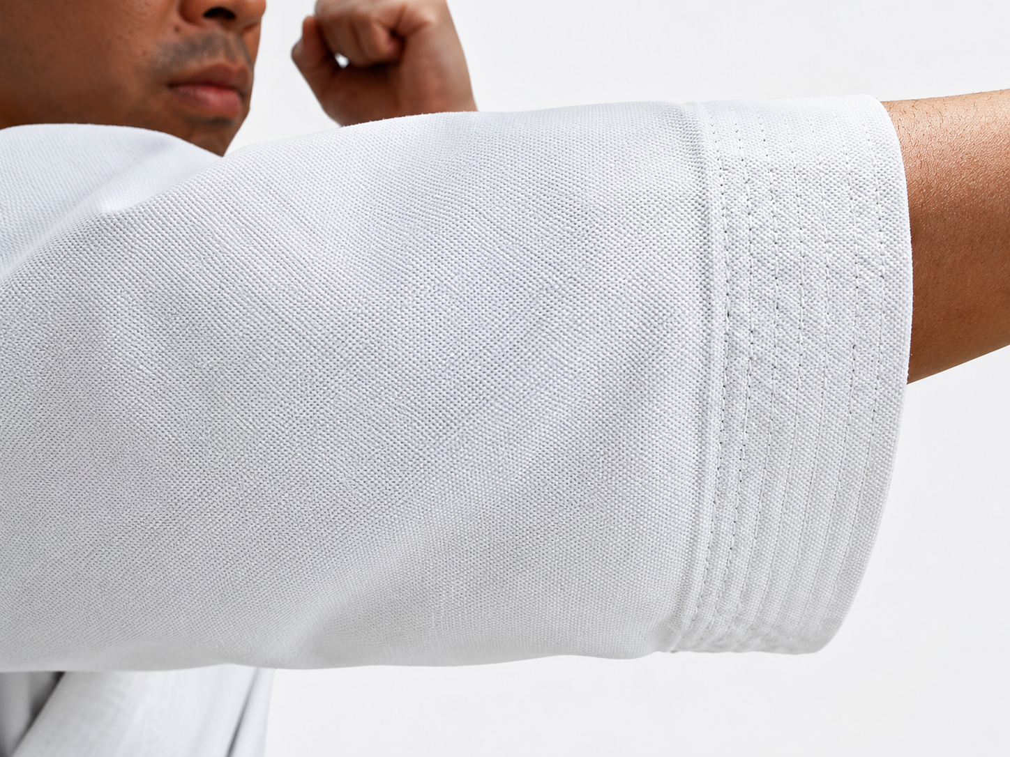 Close-up detail of the reinforced sleeve stitching and heavy cotton canvas texture on the Shureido K10 karate uniform.
