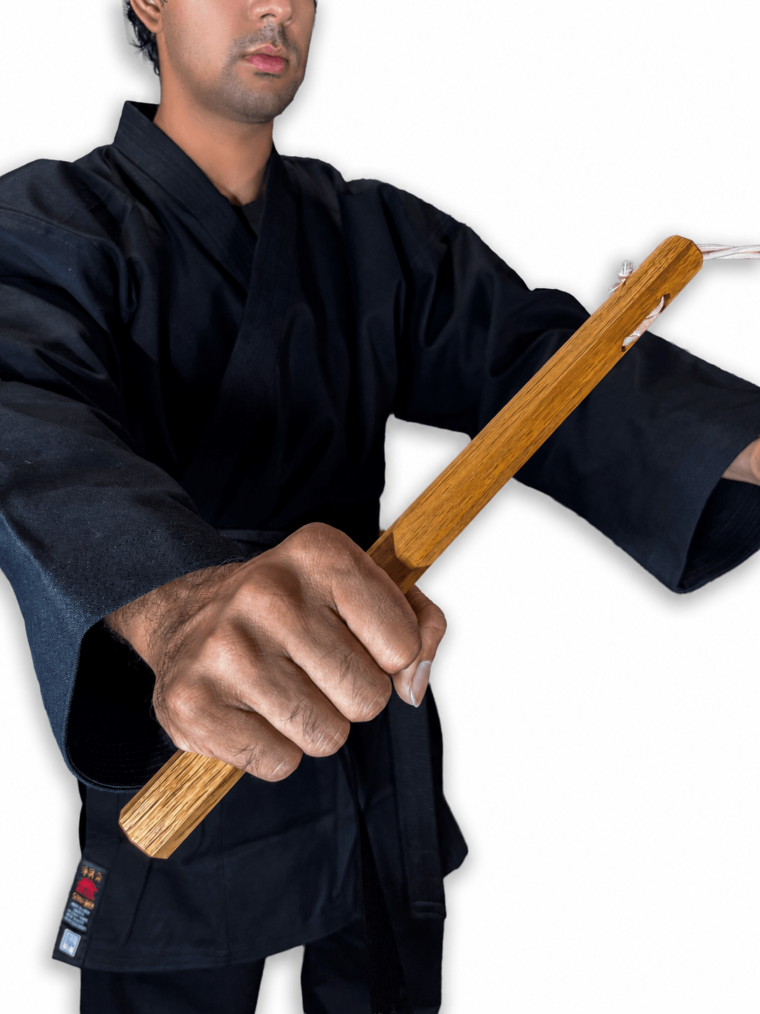 Close-up product view of traditional Shureido Okinawan wooden nunchaku held horizontally, showing the two wood handles, connecting cord, and natural grain.