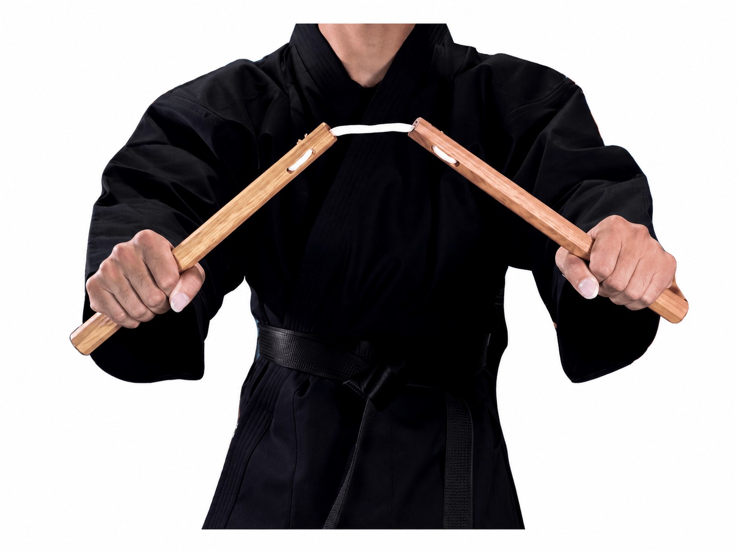 Close-up of a martial artist in a black karate gi holding traditional Shureido wooden nunchaku, showing the octagonal handles and connecting cord.