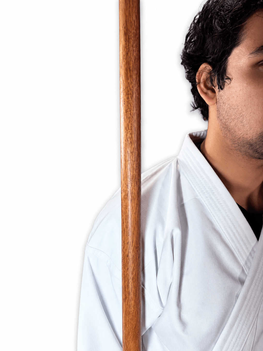 Karate practitioner standing upright holding a traditional Shureido Okinawan wooden bo staff vertically in a classic kobudo posture.