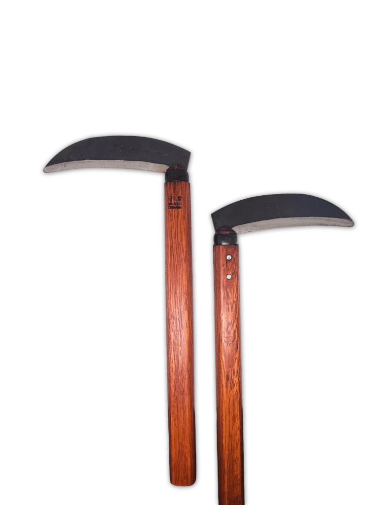 A pair of traditional Shureido Okinawan wooden kama weapons with curved metal blades arranged diagonally on a white background.